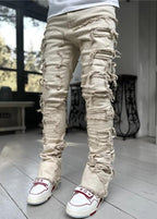 Men's stacked jeans by MANDOTOS featuring patched details, long tight fit trousers with bold style and modern denim design.