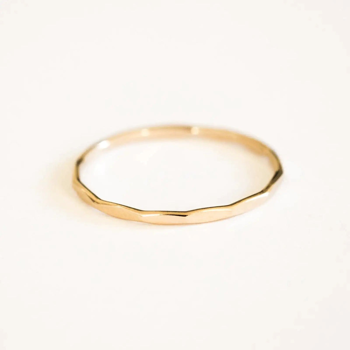 14K gold filled textured stacking ring by MANDOTOS, showcasing a hammered finish on a delicate gold band.