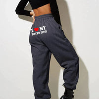 Mandotos Chic Love Print Trousers featuring stylish love-themed pattern and tailored fit, perfect for casual or trendy outfits.