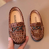 Toddler wearing stylish leather sneakers from MANDOTOS, featuring a chic design and comfortable fit.