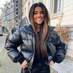Mandotos chic winter PU leather jacket displayed on a hanger, featuring a stylish design and smooth black leather finish.
