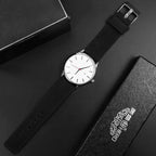 Mandotos classic leather timepiece with a black leather strap and round silver watch face showing time and minimalist design.