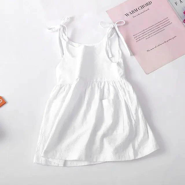 Toddler wearing a light blue cotton sundress with white floral patterns, styled by MANDOTOS, perfect for warm weather.
