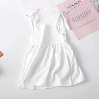 Baby girl wearing a white cotton chic toddler sundress with colorful floral patterns by MANDOTOS.