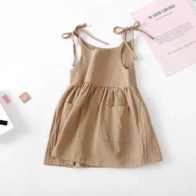Toddler girl wearing a white cotton Sundress with colorful floral patterns by MANDOTOS, perfect for warm weather.