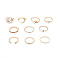 Mandotos bohemian star, moon, pearl, and leaf 10-piece gold finish ring set with stackable designs on a white background.
