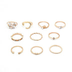 Mandotos bohemian star, moon, pearl, and leaf 10-piece gold finish ring set with stackable designs on a white background.