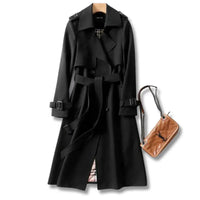 Mandotos elegant classic trench coat displayed on a hanger, showcasing its timeless design and neutral color.