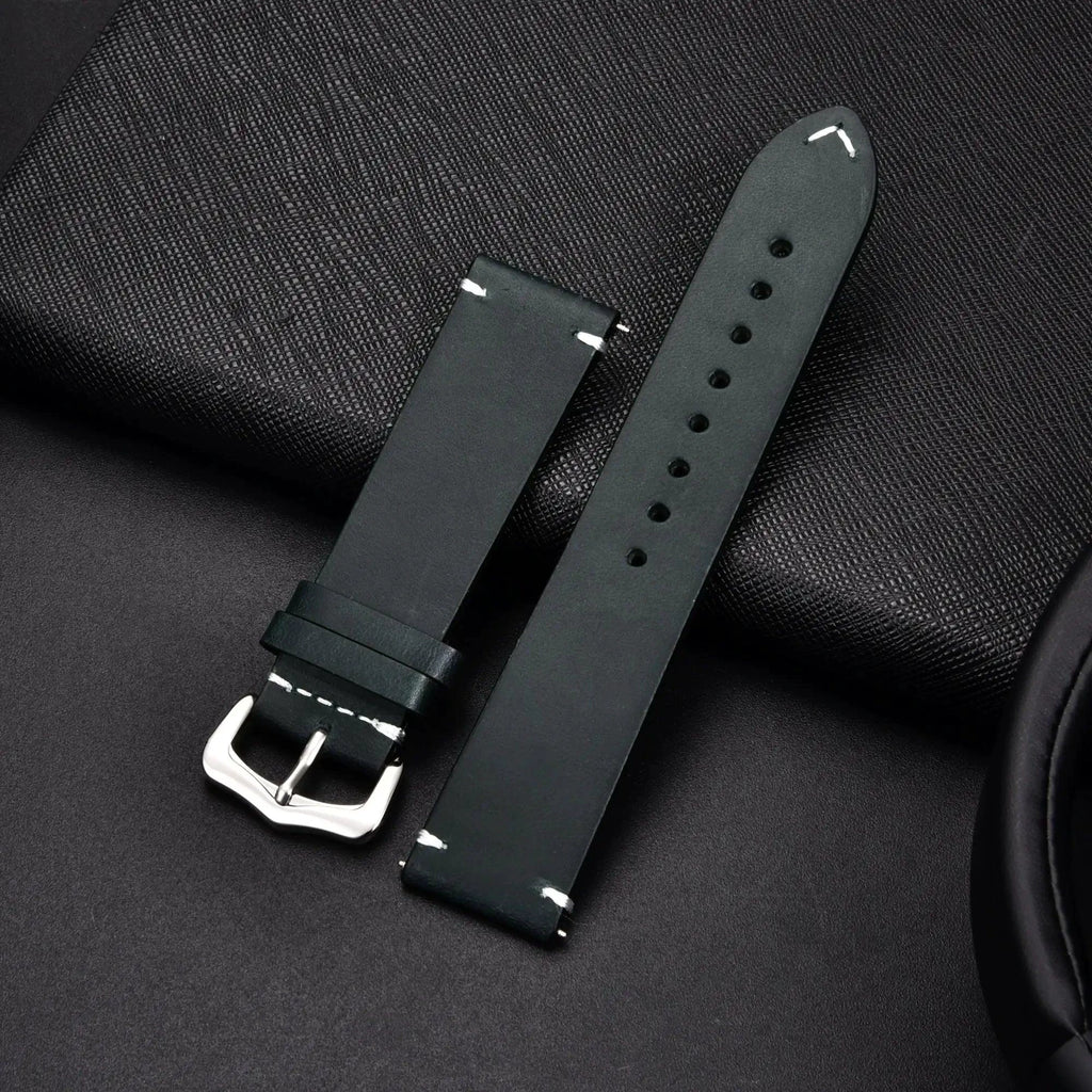 Elegant leather watch band by MANDOTOS, showing a close-up of the sleek, brown strap with stitching detail and polished metal buckle.