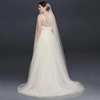 Long flowing wedding veil by MANDOTOS, ElegantBride V14 with delicate lace edging and soft tulle fabric for bridal elegance.