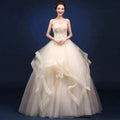 Elegant one-shoulder bridal gown by MANDOTOS INTERNATIONAL featuring flowing fabric and intricate details for special occasions.