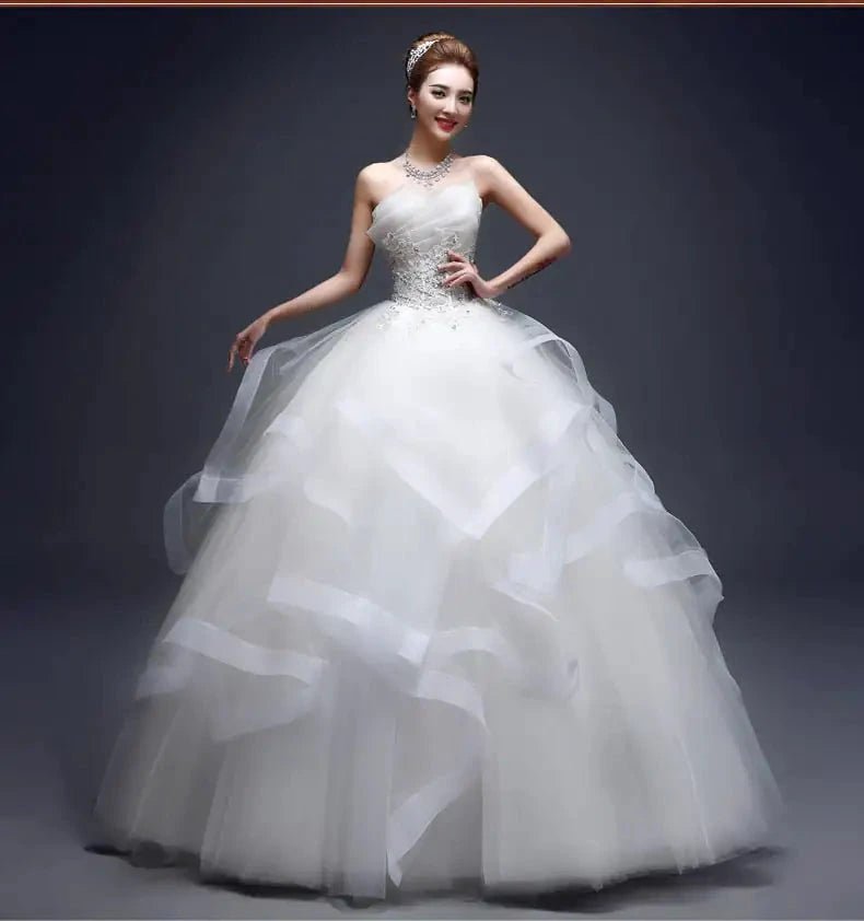 Elegant one-shoulder bridal gown by MANDOTOS INTERNATIONAL featuring flowing fabric and intricate design for a sophisticated wedding look.
