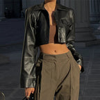 Black Vogue PU cropped jacket by MANDOTOS INTERNATIONAL, featuring a stylish, fitted design with a collar and zipper front.