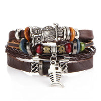 Layered leather charm bracelet by MANDOTOS featuring multiple leather strands and metal charms on a neutral background.