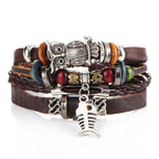 Layered leather charm bracelet by MANDOTOS featuring multiple leather strands and metal charms on a neutral background.