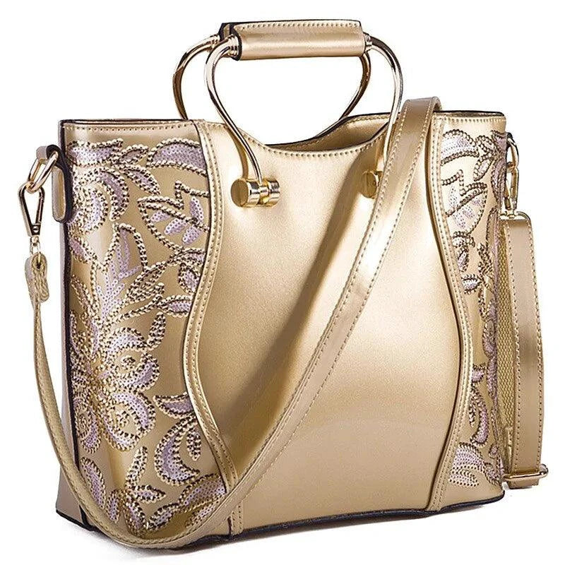 Mandotos elegant floral leather tote bag in burgundy with embroidered floral design and a matching crossbody strap.