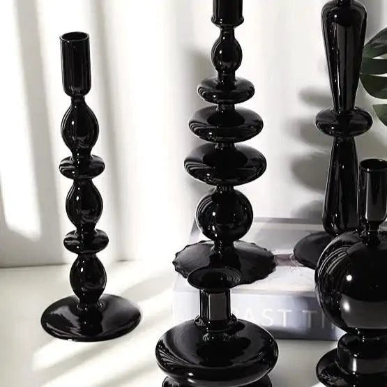 Mandotos Elegant Rue black glass candlestick holder on a table, perfect as a decorative centerpiece or gift idea.