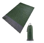 MANDOTOS sandproof portable beach mat laid flat on sandy shore, lightweight and easy to carry for beach outings.