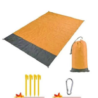 Mandotos sandproof portable beach mat spread on sandy shore, lightweight and easy to carry for outdoor seaside relaxation.