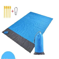 Mandotos sandproof portable beach mat spread out on sandy shore, lightweight and easy to carry for beach outings.