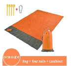 Mandotos sandproof portable beach mat spread on sandy shore, lightweight and waterproof for easy beach outings.