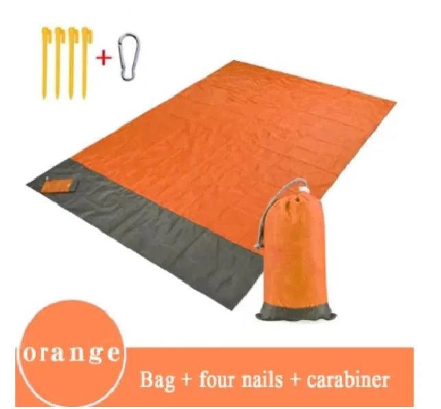 Mandotos sandproof portable beach mat spread on sandy shore, lightweight and waterproof for easy beach outings.