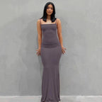 Mandotos sleek satin backless gown displayed on a mannequin, featuring a smooth, shiny fabric and elegant design.