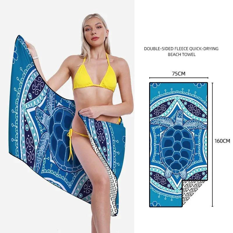 Mandotos SwiftDry patterned beach towel with colorful geometric design laid out on sandy beach.