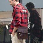 Vintage leather messenger bag by MANDOTOS, showing the classic brown leather design with adjustable shoulder strap and front flap.