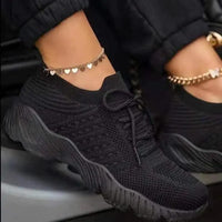Mandotos walking shoes in black with white soles, featuring breathable mesh material and secure laces for comfortable outdoor walking.